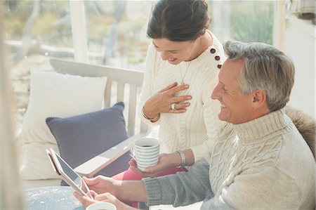 Mature couple drinking coffee and using digital tablet on porch Foto de stock - Sin royalties Premium, Código: 6113-08985745
