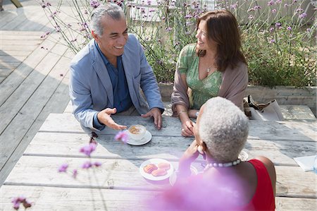 simsearch:6122-07697023,k - Mature friends talking and drinking coffee at patio table Stock Photo - Premium Royalty-Free, Code: 6113-08985746