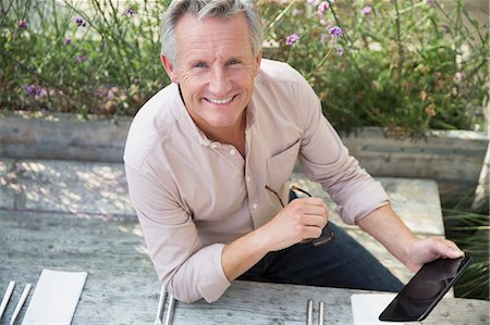 simsearch:6124-09143740,k - Portrait smiling senior man using digital tablet on patio Stock Photo - Premium Royalty-Free, Code: 6113-08985750