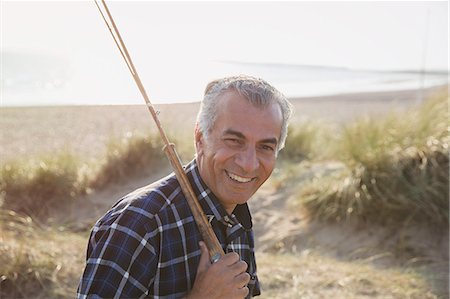 simsearch:6113-09131508,k - Portrait smiling senior man with fishing rod walking on sunny beach Foto de stock - Sin royalties Premium, Código: 6113-08985704