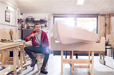 simsearch:6113-08985850,k - Male carpenter drinking tea next to wood boat in workshop Stock Photo - Premium Royalty-Free, Code: 6113-08985848
