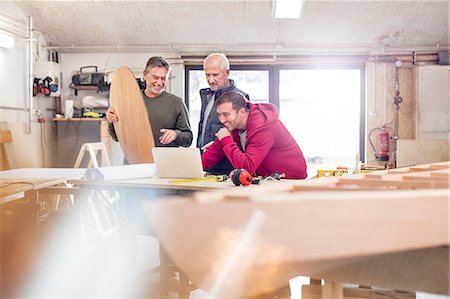 family business owner male - Male carpenters using laptop near wood boat in workshop Stock Photo - Premium Royalty-Free, Code: 6113-08985857