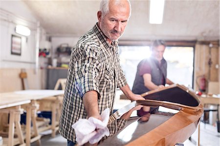 simsearch:6113-08985839,k - Senior man finishing, wiping wood kayak in workshop Stock Photo - Premium Royalty-Free, Code: 6113-08985854