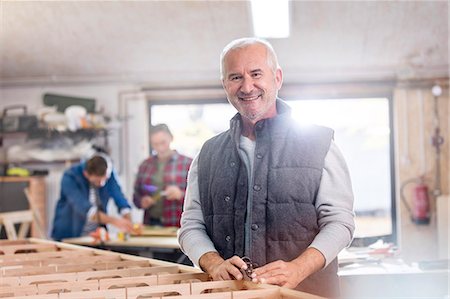 stolz - Portrait smiling male carpenter working on wood boat in workshop Stockbilder - Premium RF Lizenzfrei, Bildnummer: 6113-08985860