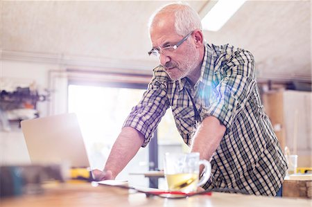 simsearch:6113-08985856,k - Serious senior male carpenter using laptop in workshop Stock Photo - Premium Royalty-Free, Code: 6113-08985874