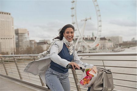 simsearch:6108-06906506,k - Portrait smiling woman bike riding on bridge over Thames River near Millennium Wheel, London, UK Stock Photo - Premium Royalty-Free, Code: 6113-08985999