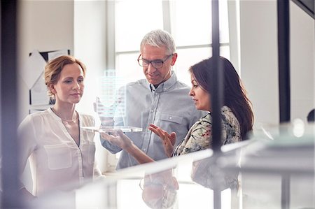 futuristic offices - Architects examining plastic model in office Stock Photo - Premium Royalty-Free, Code: 6113-08985912