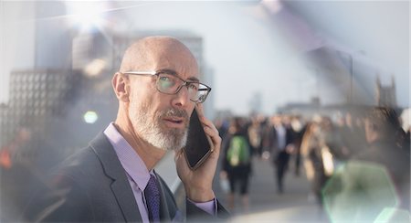 simsearch:6113-07961595,k - Serious businessman talking on cell phone on busy urban street Stock Photo - Premium Royalty-Free, Code: 6113-08986053