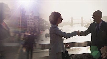 simsearch:6113-08986067,k - Silhouette business people handshaking on sunny bridge over River Thames, London, UK Foto de stock - Royalty Free Premium, Número: 6113-08986085