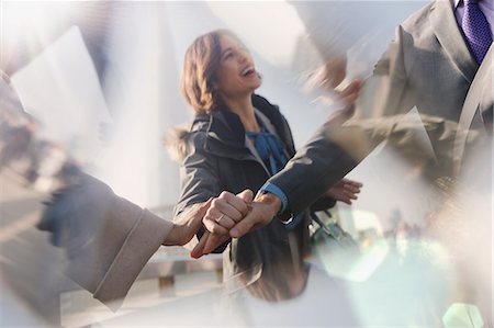 Smiling businesswoman behind handshaking business people Stock Photo - Premium Royalty-Free, Code: 6113-08986013