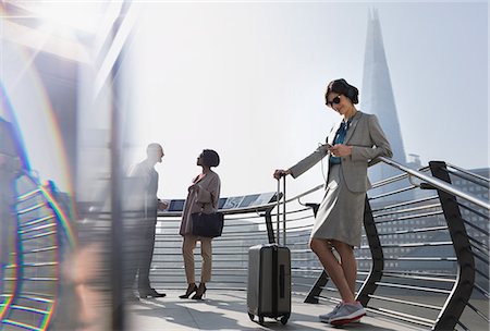 shoe worm eye view - Businesswoman with suitcase listening to music with smart phone and headphones, London, UK Foto de stock - Sin royalties Premium, Código: 6113-08986034