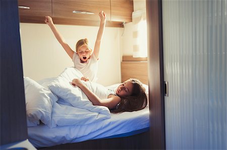 Sisters waking and stretching on bed in motor home Stock Photo - Premium Royalty-Free, Code: 6113-08909872