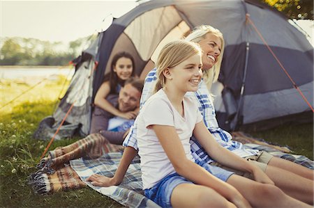 Smiling family relaxing outside campsite tent Foto de stock - Sin royalties Premium, Código: 6113-08909884