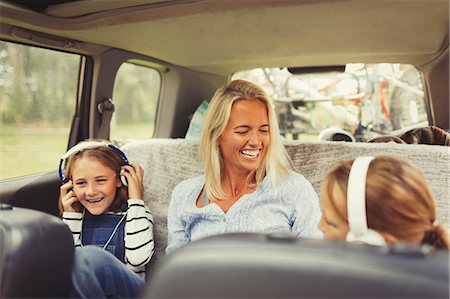 Laughing mother and daughters with headphones in back seat of car Foto de stock - Sin royalties Premium, Código: 6113-08909888