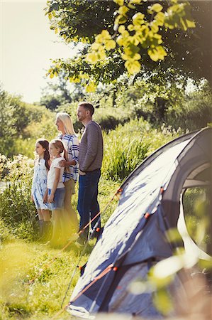 simsearch:6113-08909960,k - Family standing at sunny campsite tent Stock Photo - Premium Royalty-Free, Code: 6113-08909958