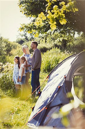 simsearch:6113-07906346,k - Family standing at sunny campsite tent Foto de stock - Sin royalties Premium, Código: 6113-08909958