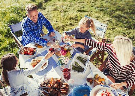 simsearch:6113-08521556,k - Family toasting wine and water glasses at sunny lunch patio table Stock Photo - Premium Royalty-Free, Code: 6113-08909960