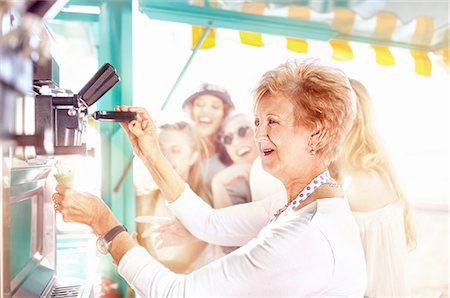 Smiling senior female business owner serving ice cream at food cart Stock Photo - Premium Royalty-Free, Code: 6113-08909996