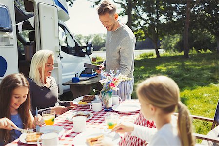 Family eating breakfast at table outside sunny motor home Stock Photo - Premium Royalty-Free, Code: 6113-08909918