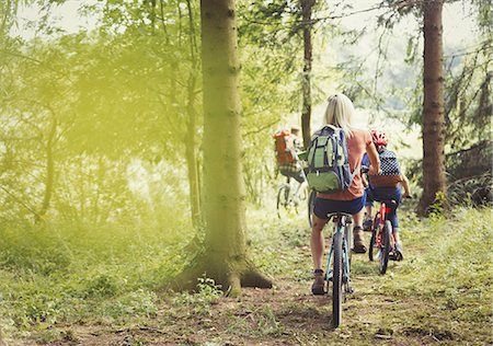 Family mountain biking on trail in woods Stock Photo - Premium Royalty-Free, Code: 6113-08909924