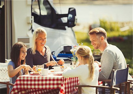 simsearch:6113-08909953,k - Family enjoying breakfast at table outside sunny motor home Fotografie stock - Premium Royalty-Free, Codice: 6113-08909928