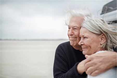 simsearch:6113-07589489,k - Affectionate senior couple hugging and looking away on beach Stock Photo - Premium Royalty-Free, Code: 6113-08910045