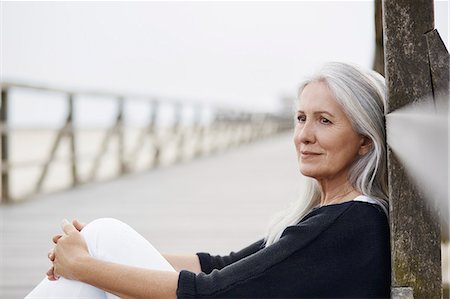 simsearch:649-03566205,k - Pensive senior woman relaxing on beach boardwalk Stock Photo - Premium Royalty-Free, Code: 6113-08910067