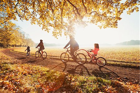 recreation - Young family bike riding in sunny autumn park Stock Photo - Premium Royalty-Free, Code: 6113-08910086