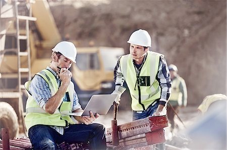 Foreman and construction worker using laptop at construction site Stock Photo - Premium Royalty-Free, Code: 6113-08910022