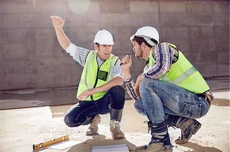 Construction worker and engineer talking at sunny construction site Stock Photo - Premium Royalty-Free, Code: 6113-08910025