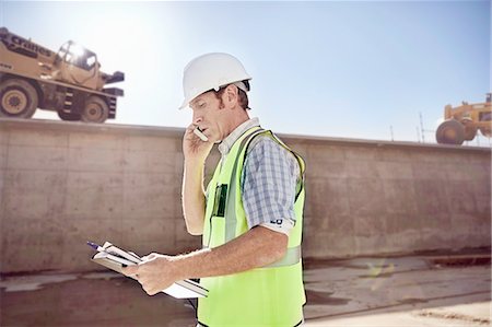 engineer (male) - Construction worker foreman talking on cell phone at sunny construction site Stock Photo - Premium Royalty-Free, Code: 6113-08910030
