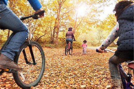 recreation bicycling - Young family bike riding in autumn woods Stock Photo - Premium Royalty-Free, Code: 6113-08910156