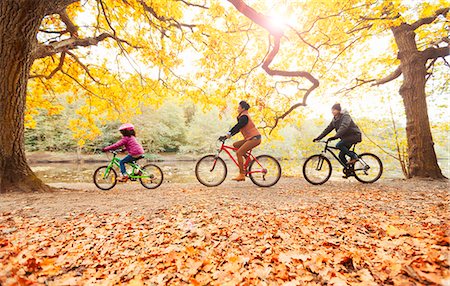 simsearch:6113-09168811,k - Young family bike riding in autumn park Stock Photo - Premium Royalty-Free, Code: 6113-08910168