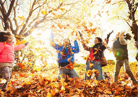 simsearch:649-09036474,k - Playful young family throwing autumn leaves in sunny park Foto de stock - Royalty Free Premium, Número: 6113-08910184