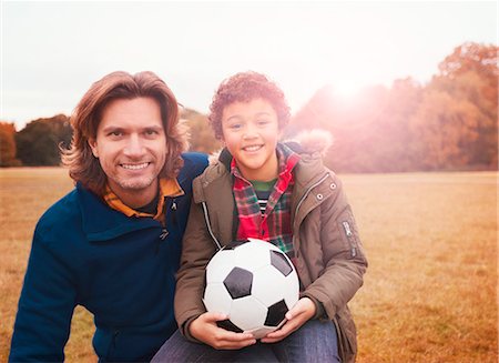 simsearch:655-03458071,k - Portrait smiling father and son with soccer ball in park grass Stock Photo - Premium Royalty-Free, Code: 6113-08910190