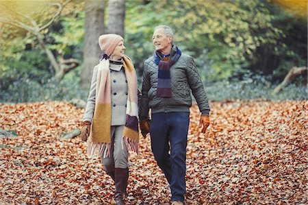 Senior couple walking in autumn leaves in park Stock Photo - Premium Royalty-Free, Code: 6113-08910196