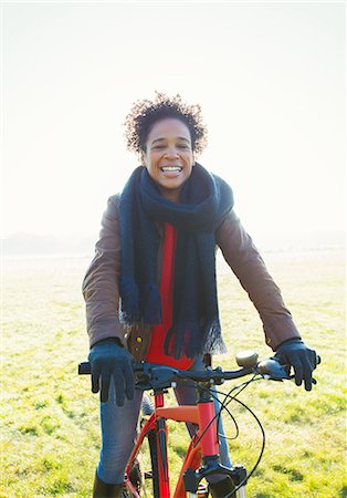 simsearch:6113-08927755,k - Portrait smiling woman bike riding in sunny park grass Foto de stock - Sin royalties Premium, Código: 6113-08910123