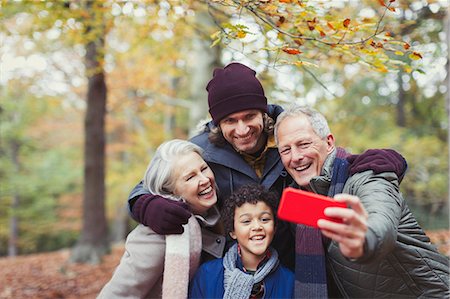 enthusiastic senior couple on amusement park - Multi-generation family taking selfie with camera phone in autumn woods Stock Photo - Premium Royalty-Free, Code: 6113-08910131