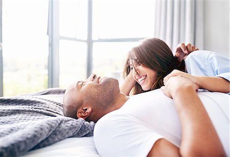 simsearch:649-07437363,k - Smiling couple laying and cuddling on bed Photographie de stock - Premium Libres de Droits, Code: 6113-08910254