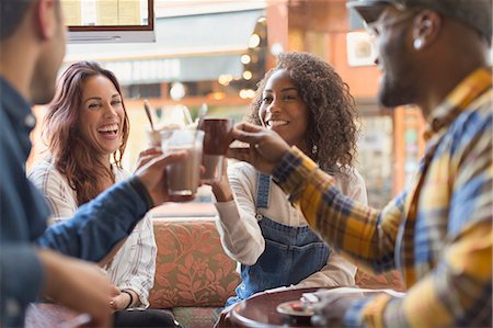 simsearch:6113-08321133,k - Smiling friends toasting coffee cups in cafe Stock Photo - Premium Royalty-Free, Code: 6113-08927646