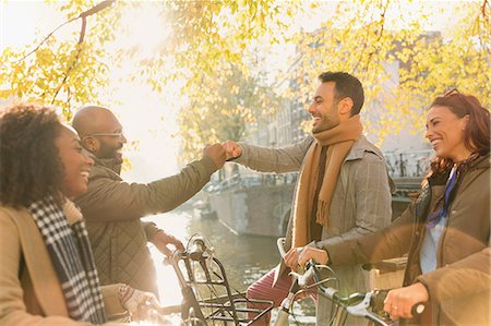 simsearch:6113-08927779,k - Friends greeting with fist bump along autumn canal Photographie de stock - Premium Libres de Droits, Code: 6113-08927649