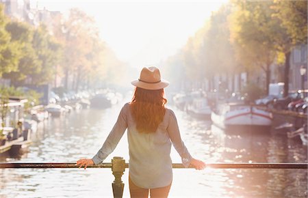 simsearch:6113-08927691,k - Woman wearing hat looking at sunny autumn canal view, Amsterdam Foto de stock - Sin royalties Premium, Código: 6113-08927657