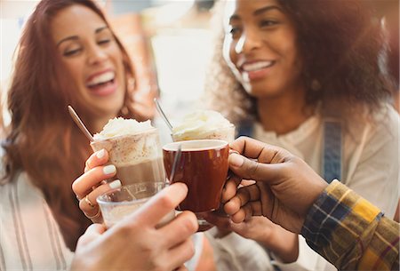 simsearch:6113-08321133,k - Smiling friends toasting  milkshakes and coffee cups in cafe Stock Photo - Premium Royalty-Free, Code: 6113-08927654