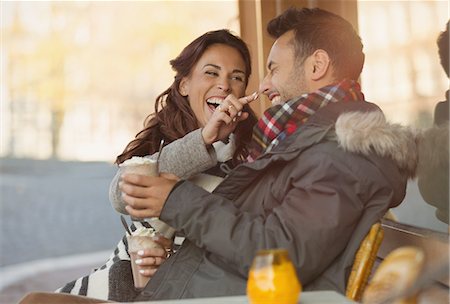 simsearch:6113-08927692,k - Playful young couple with milkshake at sidewalk cafe Foto de stock - Sin royalties Premium, Código: 6113-08927680