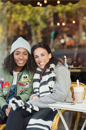 simsearch:6113-07906672,k - Portrait smiling young women friends in warm clothing at sidewalk cafe Fotografie stock - Premium Royalty-Free, Codice: 6113-08927682