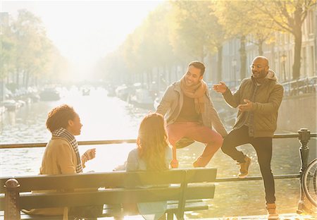 Young friends talking, hanging out on sunny urban autumn bridge over canal, Amsterdam Stockbilder - Premium RF Lizenzfrei, Bildnummer: 6113-08927765