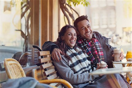 simsearch:6113-08927751,k - Portrait laughing young couple drinking milkshakes at urban sidewalk cafe Stock Photo - Premium Royalty-Free, Code: 6113-08927768