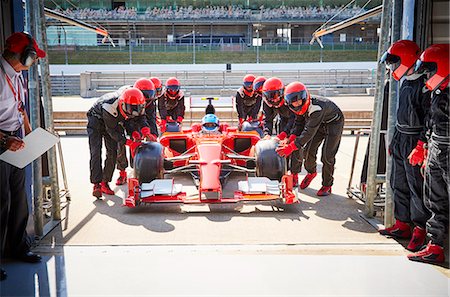 racing team working at a pit crew - Pit crew pushing formula one race car into repair garage Stock Photo - Premium Royalty-Free, Code: 6113-08927844