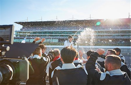 simsearch:6113-06720836,k - Formula one racing team spraying champagne on driver, celebrating victory on sports track Foto de stock - Sin royalties Premium, Código: 6113-08927848