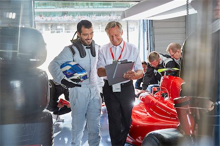 expert (male) - Manager and formula one race car driver talking in repair garage Stock Photo - Premium Royalty-Free, Code: 6113-08927868